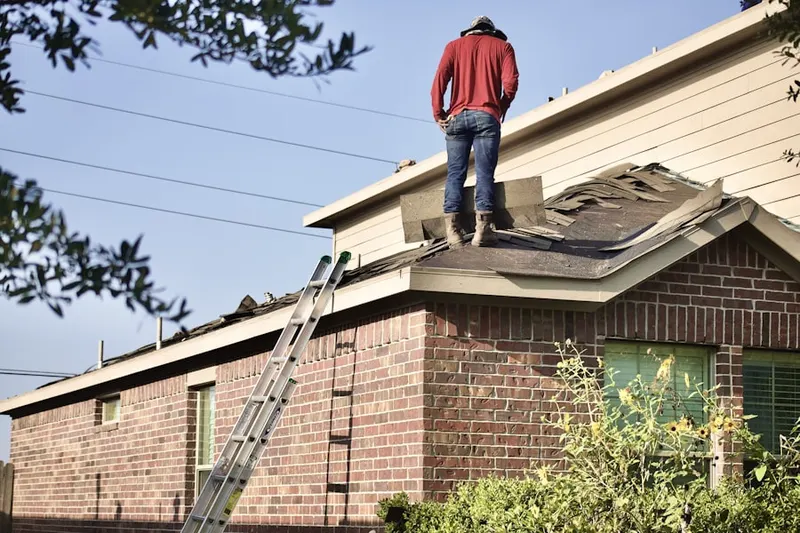 Professional roofer working on a residential roof in Pennbrooke Manor